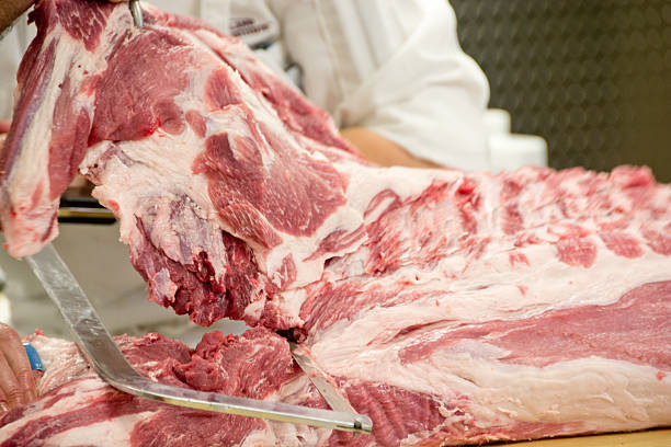 istock Slicing pork with meat saw 522718561