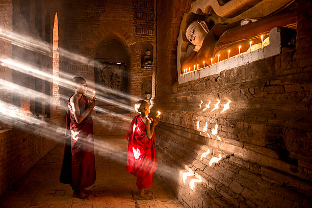 Young buddhist monks in Myanmar Two young buddhist monks praying inside the temple in Bagan, Myanmar bagan archaeological zone stock pictures, royalty-free photos & images