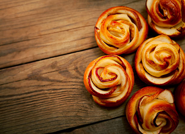 Tasty homemade apple cakes over wooden background