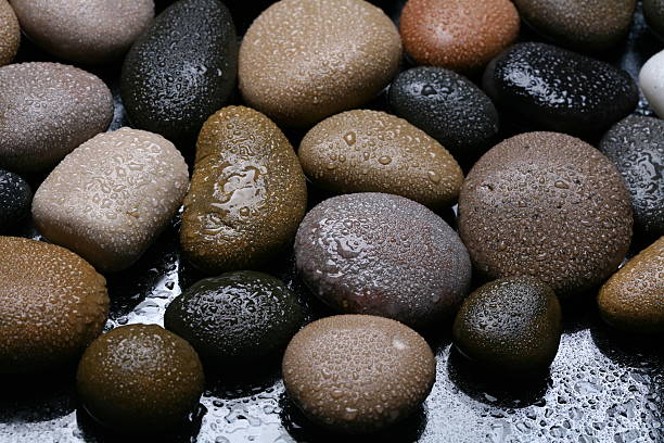 Wet colored stones background, dark pebbles. Close-up