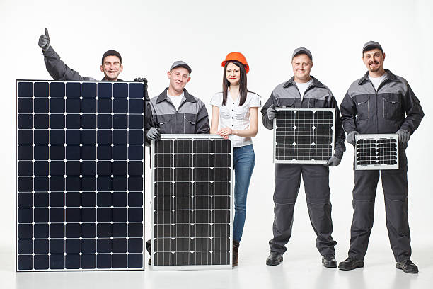 team working with a variety of solar panels stock photo