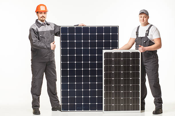 workers in uniform with solar panels stock photo