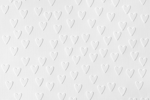 Background of white paper with embossed hearts