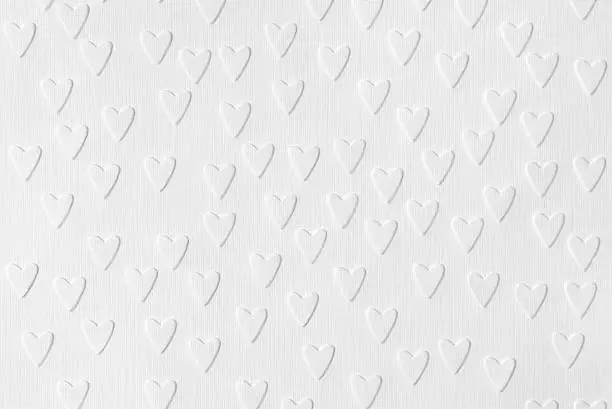 Background of white paper with embossed hearts