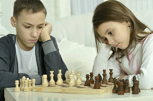 istock boy and  girl  playing chess 522729914