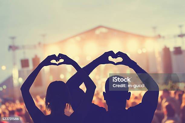 Couple Making A Heartshape Symbol For Their Favourite Band Stock Photo - Download Image Now