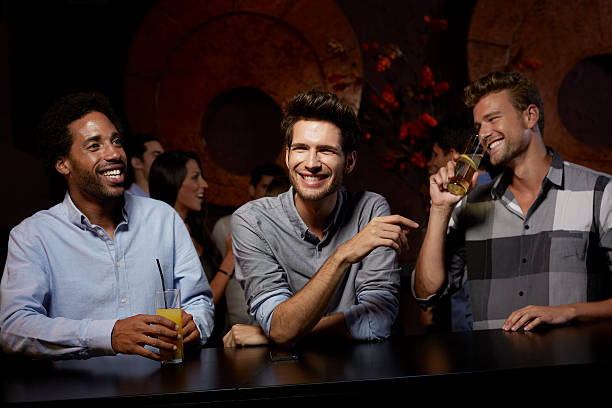 cheerful friends enjoying drinks in nightclub - real people blue white friendship 뉴스 사진 이미지