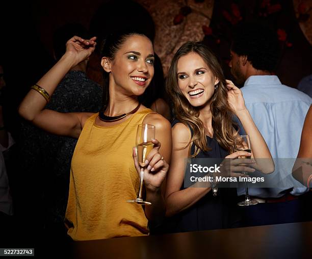 Cheerful Female Friends Dancing In Nightclub Stock Photo - Download Image Now - Party - Social Event, Drinking, Bar Counter