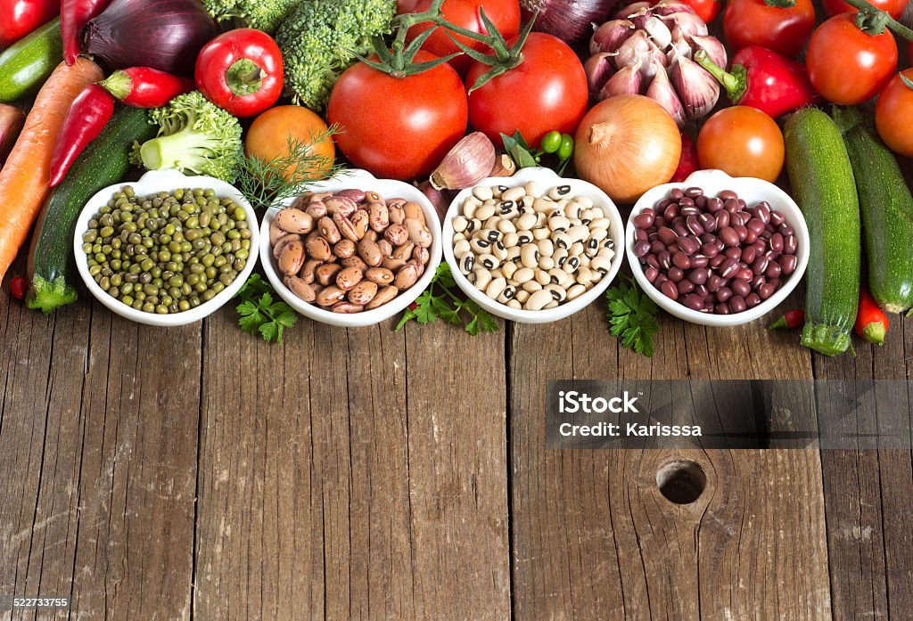 Legumes in bowls and vegetables Legumes in bowls and vegetables on a wooden table Adzuki Bean Stock Photo