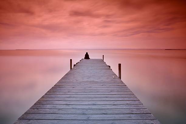 istock Lonely person sitting on pier 522734084