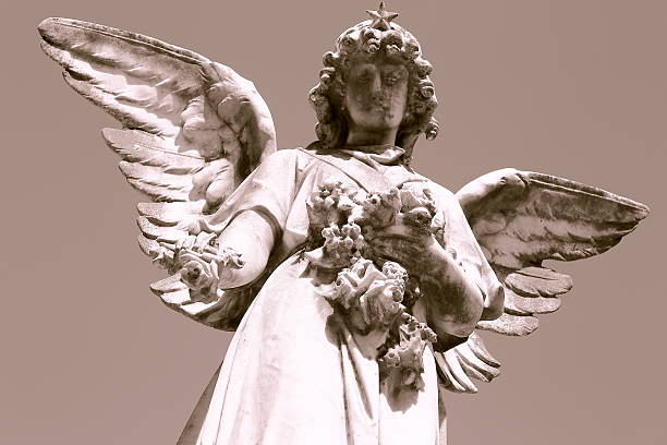 istock Angel giving flowers, at a cemetery grave 522734953
