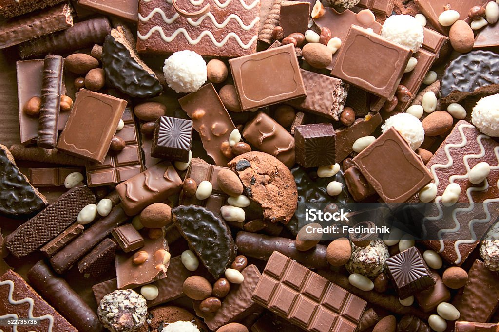 Chocolate background Chocolate background. Many pieces of chocolate, candies, cookies, biscuits, cakes and other sweets. Milk chocolate and dark chocolate. coconut candy Chocolate Stock Photo