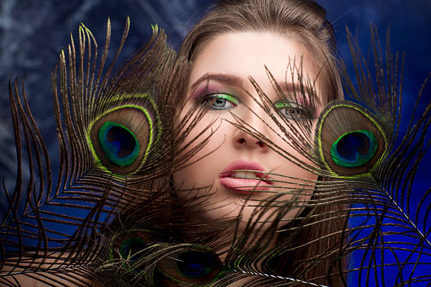 istock girl with bright  makeup and peacock feathe 522737370