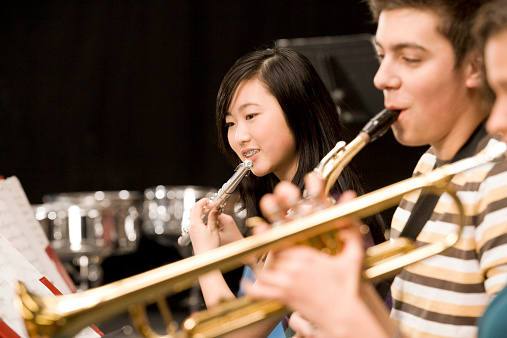 Teenage girl playing flute in high-school band