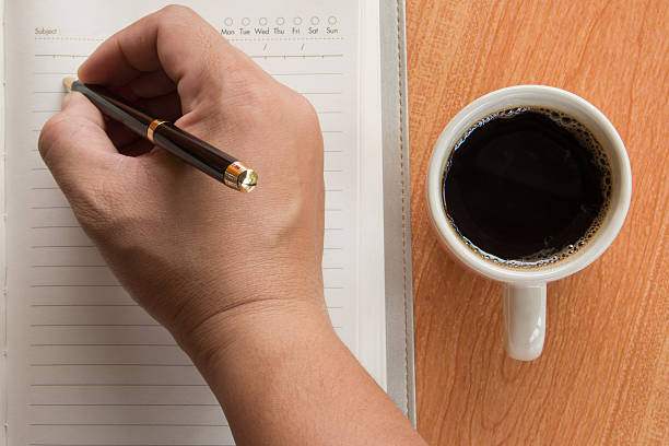 istock Hand of man writing in open notebook with cup of coffee 522738552