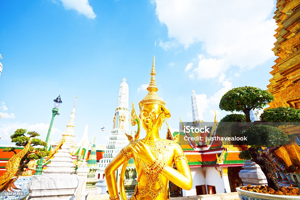 Golden thai statue smelling flower Golden thai statue smelling flower in Wat Phra Kaeo in Bangkok Architecture Stock Photo