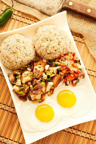 Breakfast plate with pork, eggs, rice and pico de gallo also called sisig in the Philippines