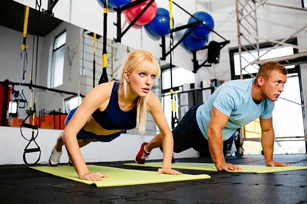 istock Young woman doing pushups with her personal trainer 522740945