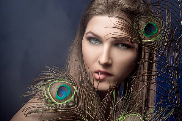 istock girl with bright  makeup and peacock feathe 522741598