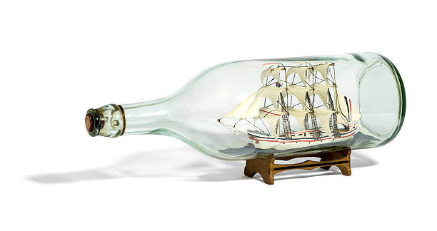istock Miniature tall ship with sails rigged in a bottle 522744828