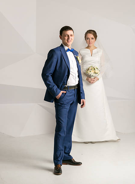 istock Happy groom in suit posing at studio with bride 522746874