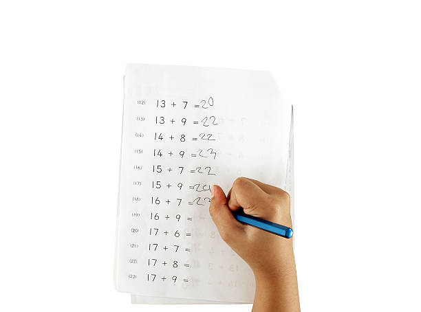 hand of little girl doing maths homework isolated on white plus the numbers exercises of primary school children, kids education concept homework paper stock pictures, royalty-free photos & images