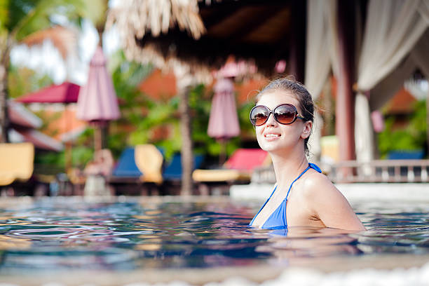 istock young woman in sunglasses in luxury pool 522748856
