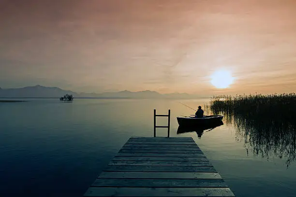 Lonely boat on silent water,  Lake Chiemsee at Sunset