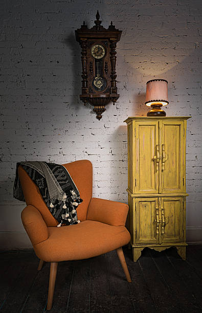 istock Orange armchair, yellow cupboard, pendulum clock and illuminated table lamp 522749610