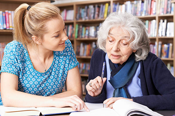 istock Senior Woman Working With Teacher In Library 522749852