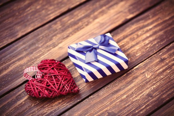 red heart shaped toy and blue gift on the brown wooden table