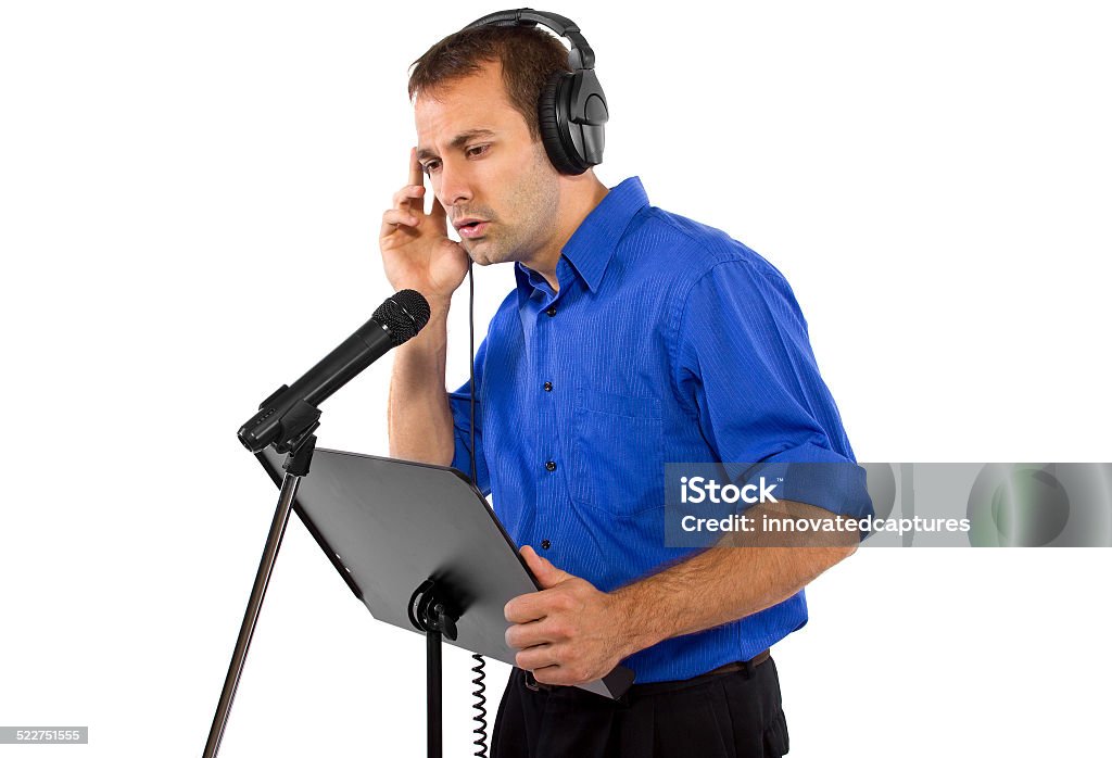 Male Voice Over Artist or Singer with a Microphone male voice over artist or singer on a microsphone wearing a blue shirt on a white background Singing Stock Photo