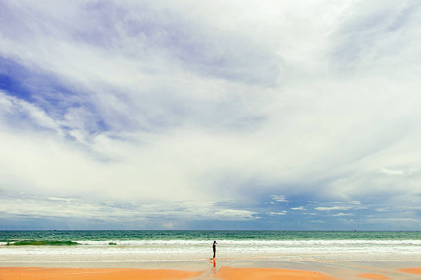 girl standing at the beach with skyline view and large sky