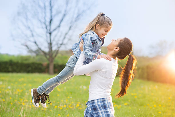istock Mother and her daughter sitting on the grass 522752634