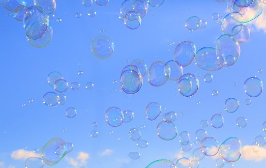 Delicate soap bubbles floating in a blue sky