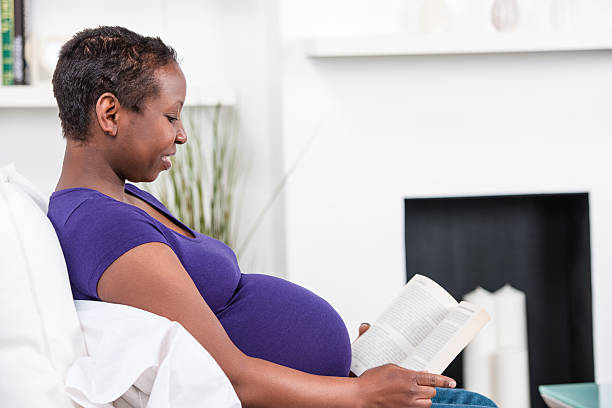 istock Pregnant Woman Relaxing On Sofa And Reading A Book 522753573
