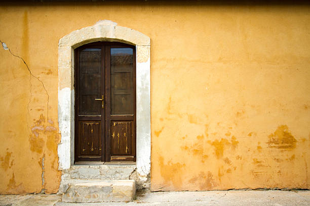 istock Old Sicilian Door in Mottled Yellow Wall 522762127