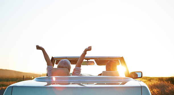 The open road is calling Rear view shot of a happy couple in a car excited about the sun rise convertible stock pictures, royalty-free photos & images