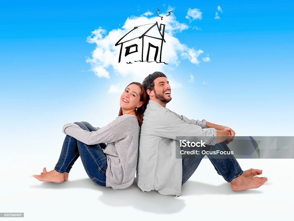 couple dreaming and imaging new house in real state concept Young attractive and modern couple in love smiling happy together sitting on floor thinking and imaging their new house, home, flat or apartment in real state concept Dreamlike Stock Photo