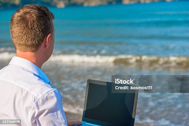 Man With Laptop At The Sea Rear View Stock Photo - Download Image Now - Adult, Adults Only, Beach