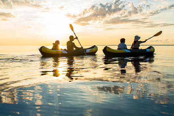 楽しんで夕暮れの海にカヤック - family kayaking kayak canoeing ストックフォトと画像