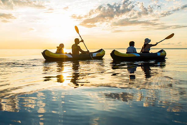 diversão caiaque no mar ao pôr do sol - family kayaking kayak canoeing imagens e fotografias de stock