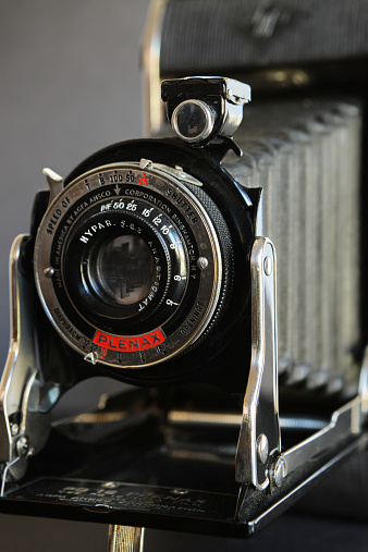 Binghampton, New York, USA - November 10, 2014: 1935 Agfa Ansco PD16 Plenax model folding bellows style camera with an f6.3 Hypar Anastigmat lens.  The camera accepted PD16 Agfa film - an 8-exposure 116 roll film with paper backing on wooden shafts, and eventually Kodak's 616 roll film on metal shafts.  The camera was originally sold with a mask to permit 16 half-size prints to a roll.  Full negative size was 2-1/4 x 4-1/4.  Today, 120 roll film can be made to work.  This upscale model included the faster f6.3 Hypar lens - standard models used an Antar f/14 or Tripar f/11 lens.  Shutters speed settings included T, B, 100, 50, and 25.  Ansco was founded in 1842 - pre-dating Kodak in the world of photography - and headquartered in Binghampton, New York.  It merged with German photography company Agfa in 1928 and marketed products until the mid-1990s, when the brand was finally purchased and allowed to fade into obsurity.