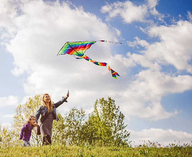 istock Mother and daughter flying kite together 522780926