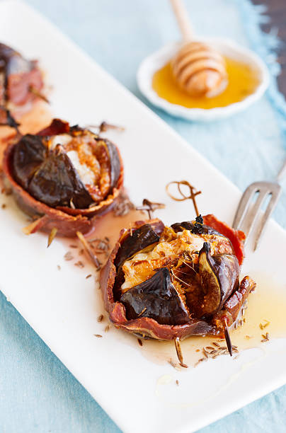 istock Baked figs with cheese wrapped in bacon 522780984
