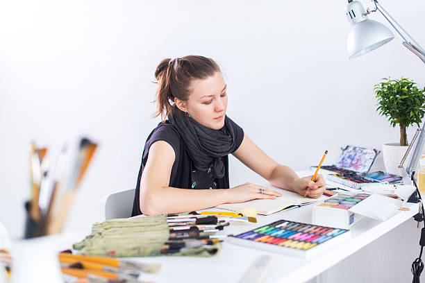 istock Young female artist drawing sketch using sketchbook with pencil at 522781212