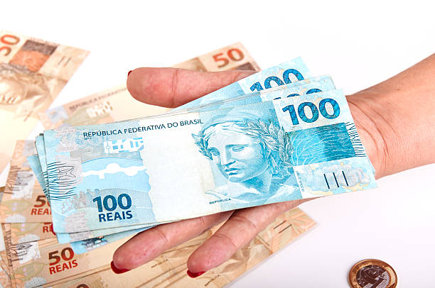 istock Woman's hand and Brazilian money 522781258