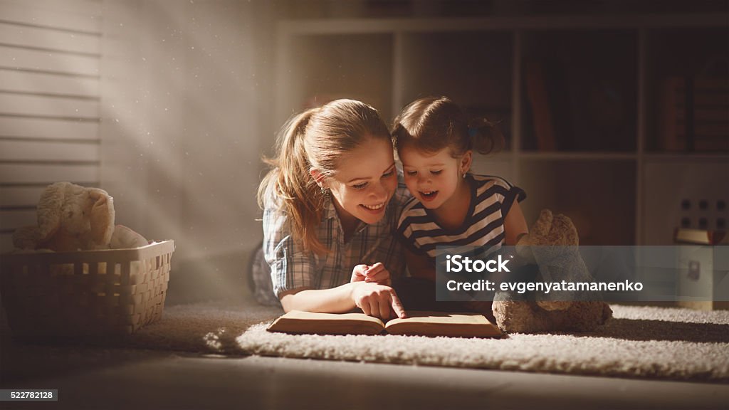 Glückliche Familie, Mutter und Tochter lesen Sie ein Buch am Abend - Lizenzfrei Lesen Stock-Foto