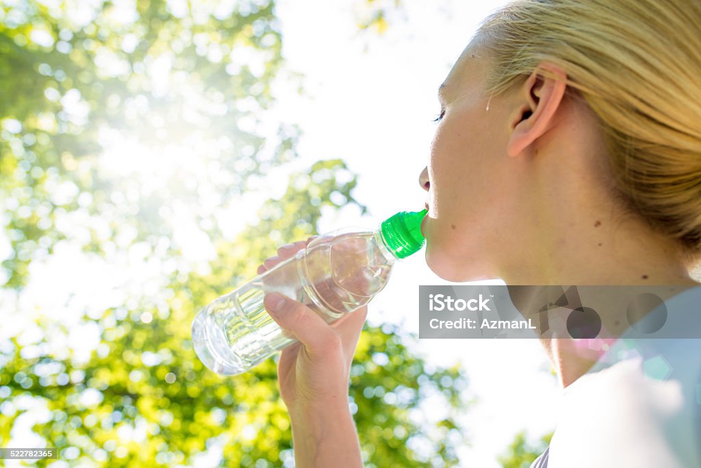 Refreshment after workout Young woman, drinking water after workout in nature. Carbonated Water Stock Photo