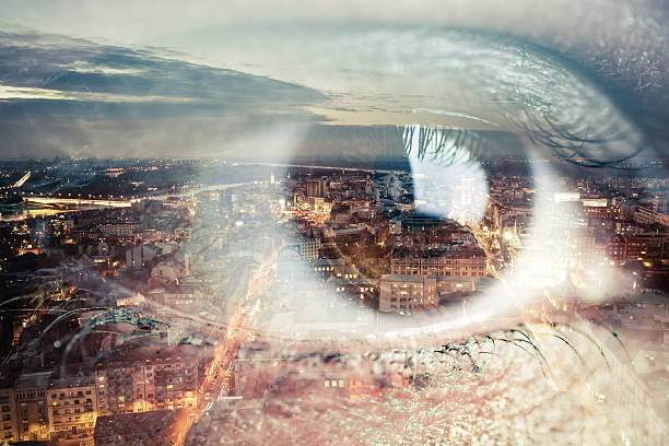Double exposure image of an eye with city stock photo